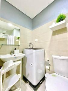 een badkamer met een wit toilet en een wastafel bij Fully equipped 1BR Condo at Shore2 near to MOA in Manilla
