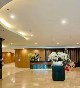 a lobby with a desk and flowers in a building at Fully equipped 1BR Condo at Shore2 near to MOA in Manila