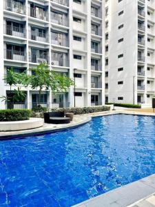 a large blue swimming pool in front of a building at Fully equipped 1BR Condo at Shore2 near to MOA in Manila