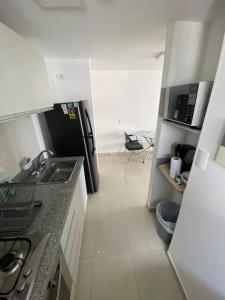 a kitchen with a sink and a refrigerator at Luxury Apto Amoblado - Piso alto - Estrenar in Bucaramanga +2 photos