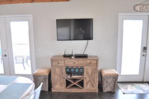 een woonkamer met een tv aan de muur bij Whitesands South Relax in comfort at this duplex within walking distance of the beach in Gulf Shores