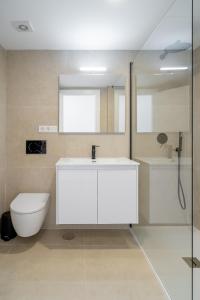 a bathroom with a white sink and a toilet at Solymar Sun & Beach Deluxe Apartments in Nerja