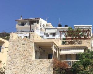 a large white building sitting on top of a hill at Stonehouse Elia Up in Myrtos