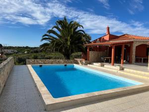 a swimming pool in front of a house at Terra da Eira - Villa mit Pool Western Algarve in Vila do Bispo
