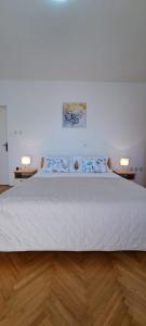 1 cama en una habitación con 2 lámparas en 2 mesas en Apartment Šego, en Kaštela