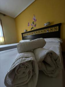 una pila de toallas sentadas encima de una cama en Hostal El Botero, en Monreal del Campo