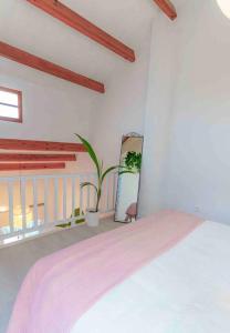 - une chambre avec un lit et une plante sur un balcon dans l'établissement UNIQUE LOFT, à Orihuela Costa