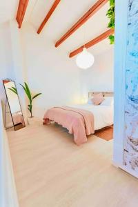 - une chambre avec un lit recouvert d'une couverture rose dans l'établissement UNIQUE LOFT, à Orihuela Costa