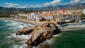 an aerial view of a beach with buildings and the ocean at Solymar Sun & Beach Deluxe Apartments in Nerja