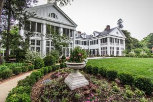 uma grande casa branca com um vaso de flores no quintal em The Duke Mansion em Charlotte