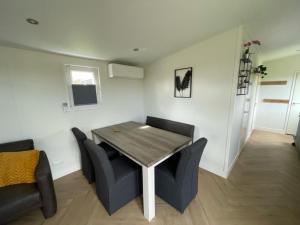 a living room with a wooden table and chairs at Chalet 't Kwedammertje in Kwadendamme