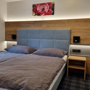 sypialnia z dużym łóżkiem z niebieskim zagłówkiem w obiekcie Das Geringer w Schladming