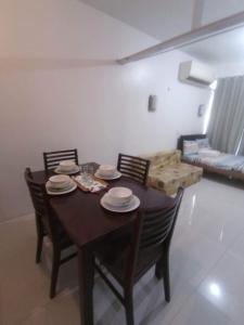 einen Esstisch mit Stühlen und Tellern darauf in der Unterkunft Queensland manor cebu city in Cebu City
