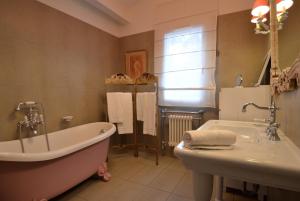 een badkamer met een bad en een wastafel bij Logis Hôtel restaurant des Pins in Bédoin