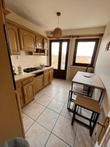 kuchnia z drewnianymi szafkami oraz stołem i krzesłami w obiekcie Appartement lumineux centre ville w mieście Châteauroux