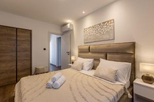 a bedroom with a large bed with two towels on it at Villa Argola in Split