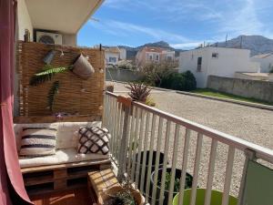 a porch with a bench on a balcony at Appartement à 20 mètres de la plage avec balcon in Marseille