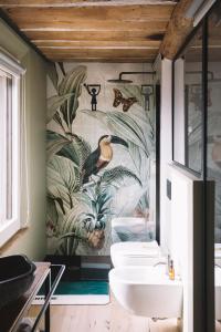 La salle de bains est pourvue de 2 lavabos et d'une fresque murale représentant des plantes. dans l'établissement Podere Selvatici, à Imola