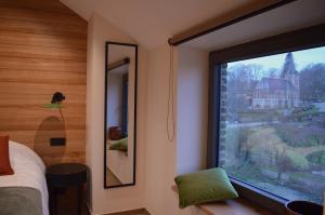 a bedroom with a window with a view of a church at La Jardinière in Érezée