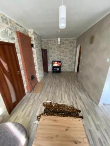 a living room with a wooden floor and a fireplace at Mārkalni in Krāslava