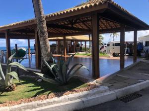 un pabellón de madera con una mesa y una palmera en apart hotel 2 quartos frente mar, en Salvador