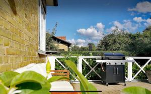 een barbecue op een veranda met een hek bij Danish villa with a lovely garden & close to Copenhagen in Gentofte