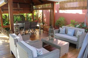 un patio esterno con tavolo e sedie in vimini di LE RUBINJO 2 a Saint-Benoît