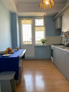 a kitchen with blue walls and a blue counter top at КВАРТИРА с видом на площадь in Shymkent