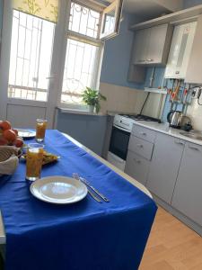 a kitchen with a table with a blue table cloth on it at КВАРТИРА с видом на площадь in Shymkent