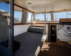 un sofá en la parte trasera de un barco con ventanas en Spacious and charming BOAT in Port Forum, en Barcelona