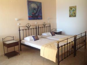 a bedroom with two beds and a painting on the wall at Archipelagos Apartments in Arkasa