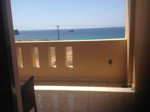 a room with a view of the ocean from a balcony at Archipelagos Apartments in Arkasa