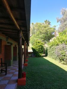 um alpendre de uma casa com um relvado verde em Hotel Rural Luna del Valle em San Agustín de Valle Fértil