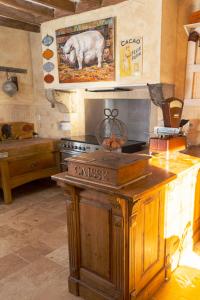 uma cozinha com uma ilha de madeira com um porco na parede em Gite La famille est dans les blés em Brinay