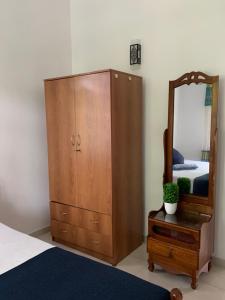- une chambre avec une commode en bois et un miroir dans l'établissement Tranquil Private Villa near Bentota Beach, à Bentota