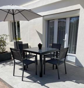 una mesa y sillas con una sombrilla en el patio en ZER GOCHOA, en Cambo-les-Bains
