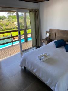 1 dormitorio con 1 cama grande y balcón en Hotel MANDALA BEACH CHIHUAHUA Naturista Nudista Opcional -Exclusivo Adultos-, en Punta del Este
