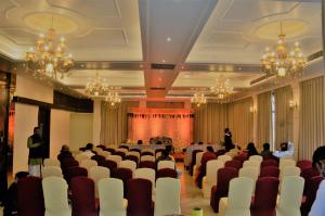 un salón de banquetes con sillas blancas y gente en él en HOTEL RIO BENARAS, en Varanasi