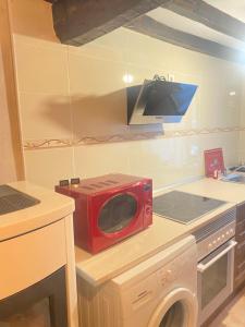 a red microwave sitting on top of a kitchen counter at Vivienda Vacacional Trespandiu in Oceño +11 photos