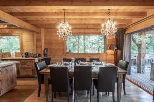 una sala da pranzo con tavolo, sedie e lampadari a braccio di Chalet Peyrlaz a Chamonix-Mont-Blanc