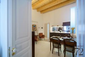 a kitchen and dining room with a table and chairs at Habitat 72 in Enna
