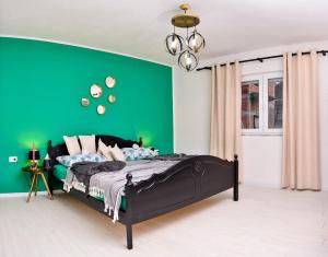 Dormitorio verde con cama y pared verde en Stela1 en Drvar