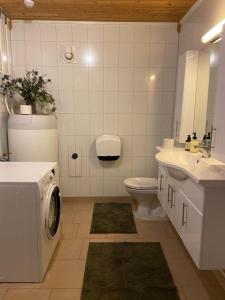 uma casa de banho com uma máquina de lavar roupa, um WC e um lavatório. em 3ART recreation em Tromsø