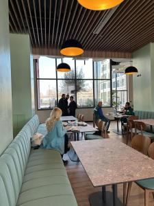 a woman sitting on a couch in a restaurant at ApartHotel Folé in Tirana