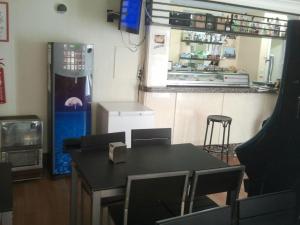 a kitchen with a table and a soda machine at Hostal Blazquez Sanchez in Béjar