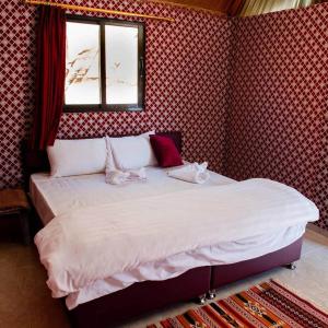 a bedroom with a large bed with a window at Abdullah wadi rum camp in Wadi Rum