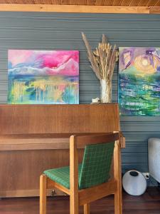 a desk with a chair and two paintings on the wall at 3ART recreation in Tromsø