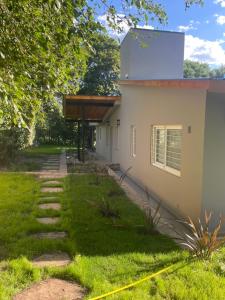 a building with a walkway next to a yard at La Franca Aparts in Villa General Belgrano