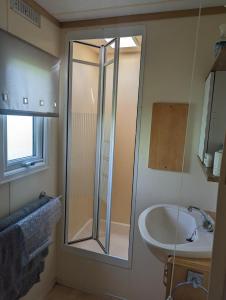 a bathroom with a shower and a sink at The Topaz Caravan HF12 in Ingoldmells +17 photos