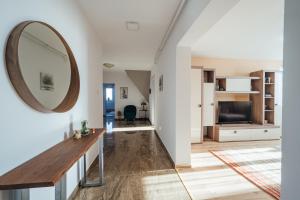 a hallway with a mirror and a living room at SkarabeuS in Odorheiu Secuiesc